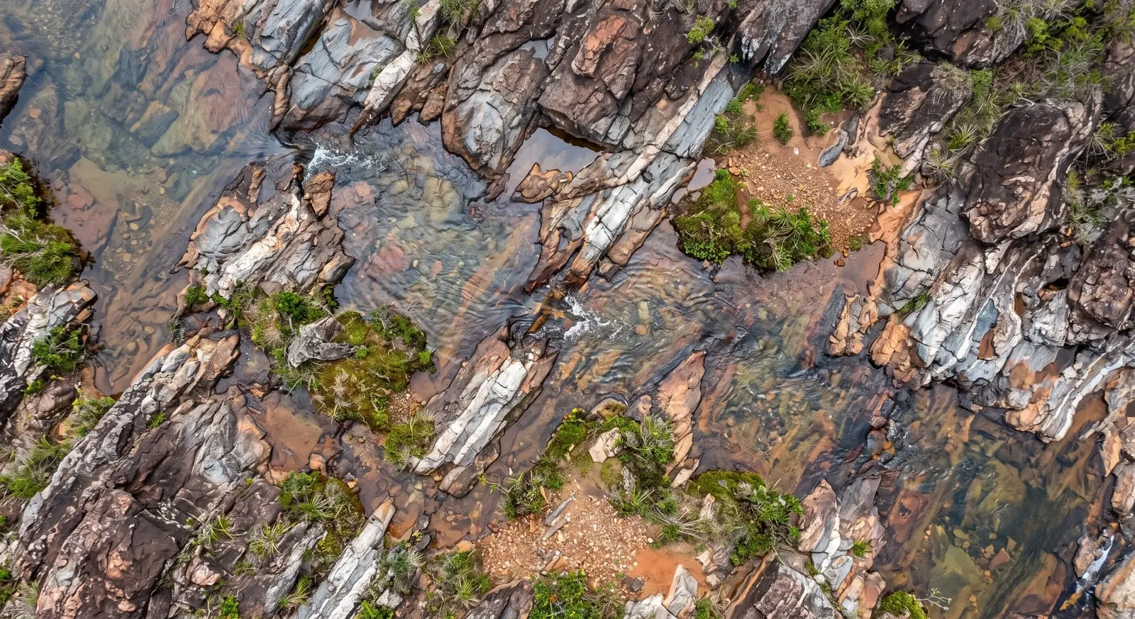Curso d'água visto de cima, entre vegetação nativa
